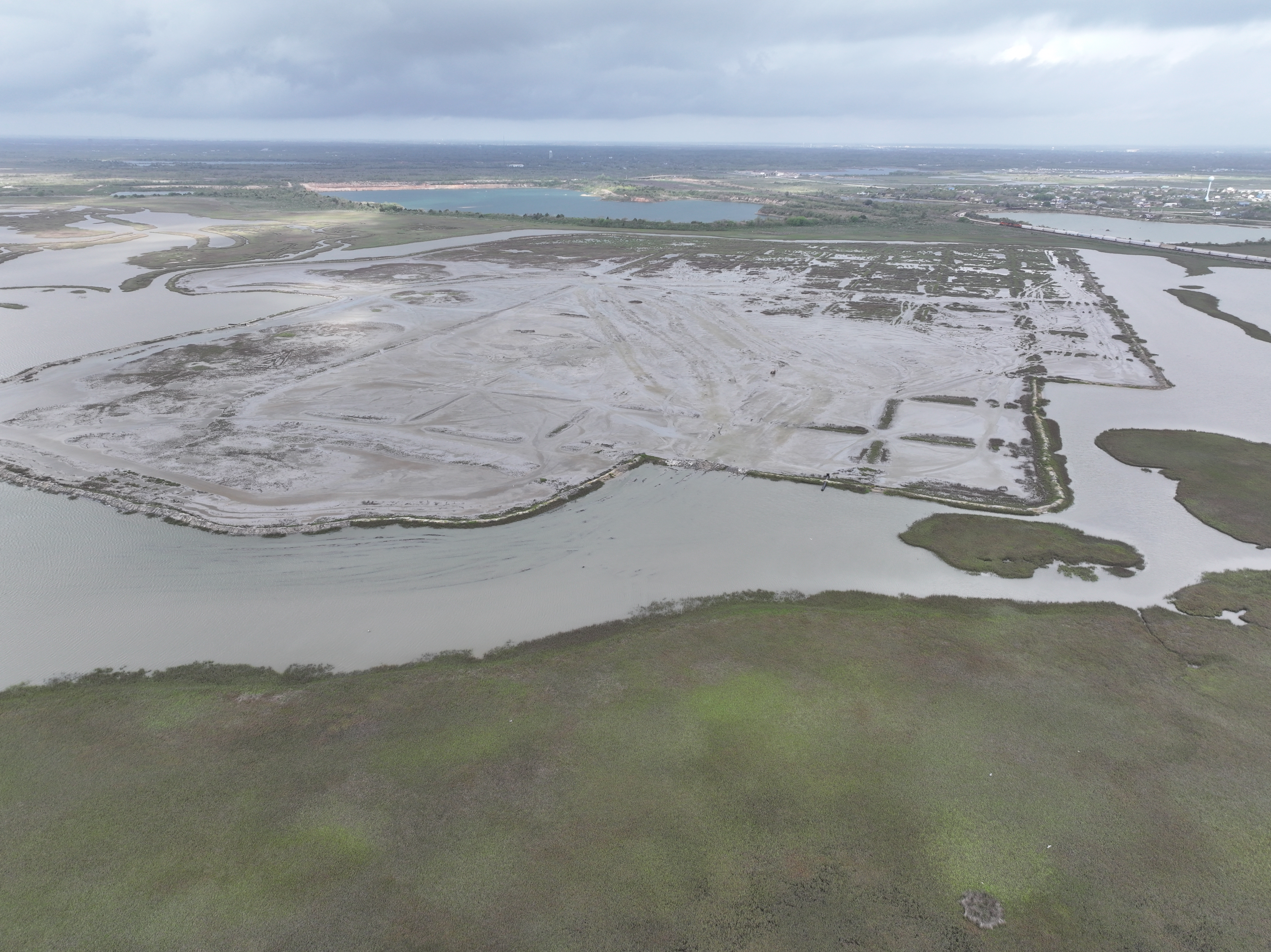 Aerial photo of a marsh undergoing placement of dredged sediment materials.